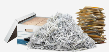 Pile of files to be shredded next to pile of shredded paper.